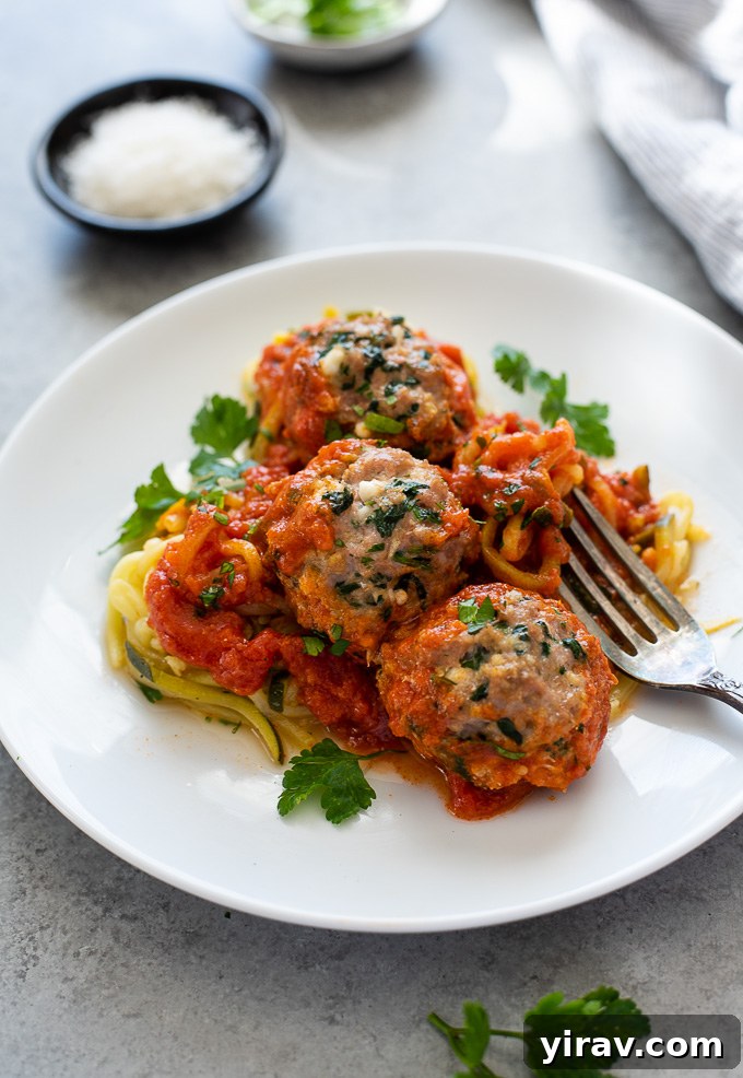 Platter of oven-baked turkey meatballs served over a bed of fresh zucchini noodles.