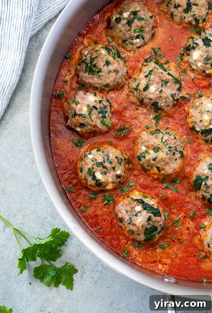 Cooked ground turkey meatballs simmering in marinara sauce in a cast iron skillet, ready to serve.