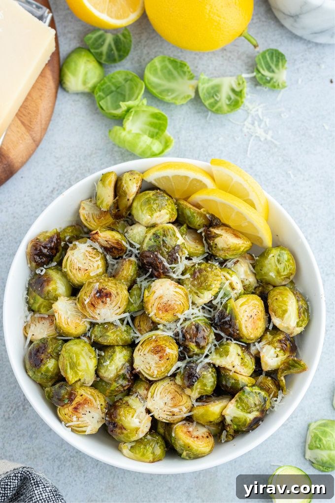 Crispy Air Fryer Brussels Sprouts 3 A close-up shot of crispy air fryer Brussels sprouts in a rustic serving bowl, generously topped with Parmesan cheese.