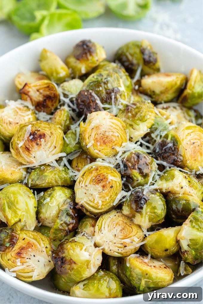 Crispy Air Fryer Brussels Sprouts 6 A vibrant bowl of crispy air fryer Brussels sprouts, freshly tossed with Parmesan cheese, perfectly showcasing their golden-brown edges.