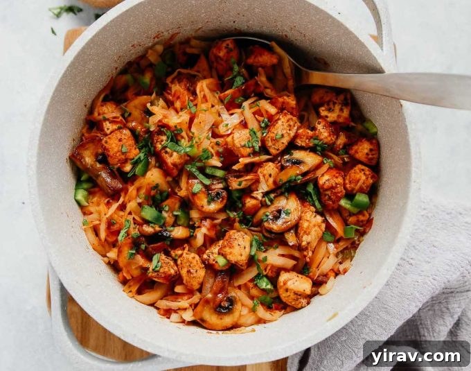 Overhead view of a wholesome one-pan chicken and cabbage meal in a white bowl.