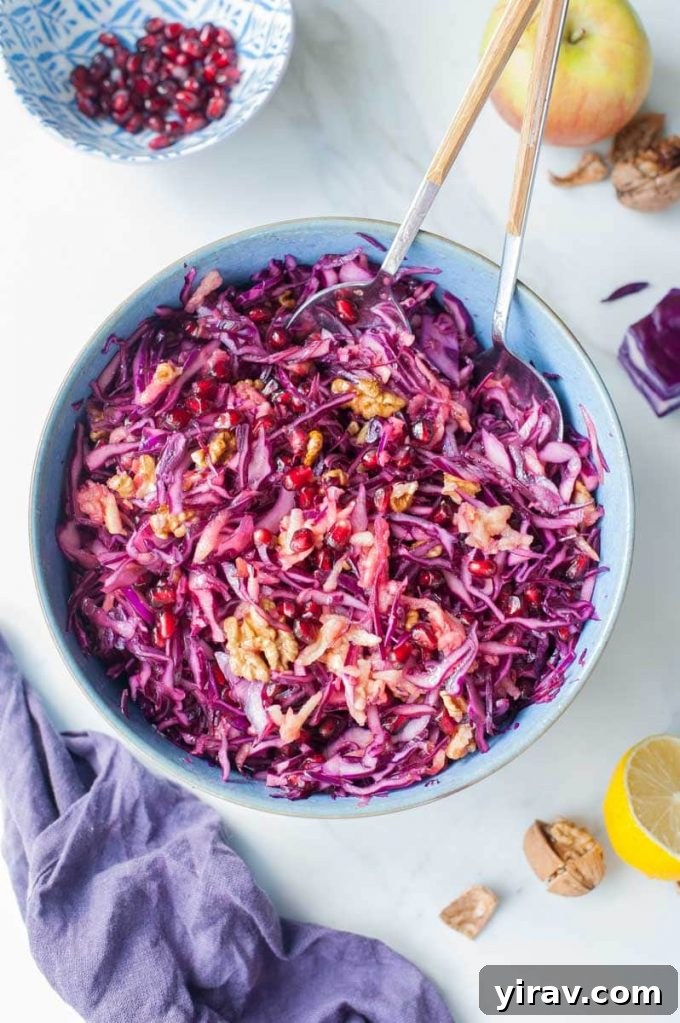 Overhead view of a beautiful blue bowl filled with vibrant Red Cabbage and Apple Slaw.