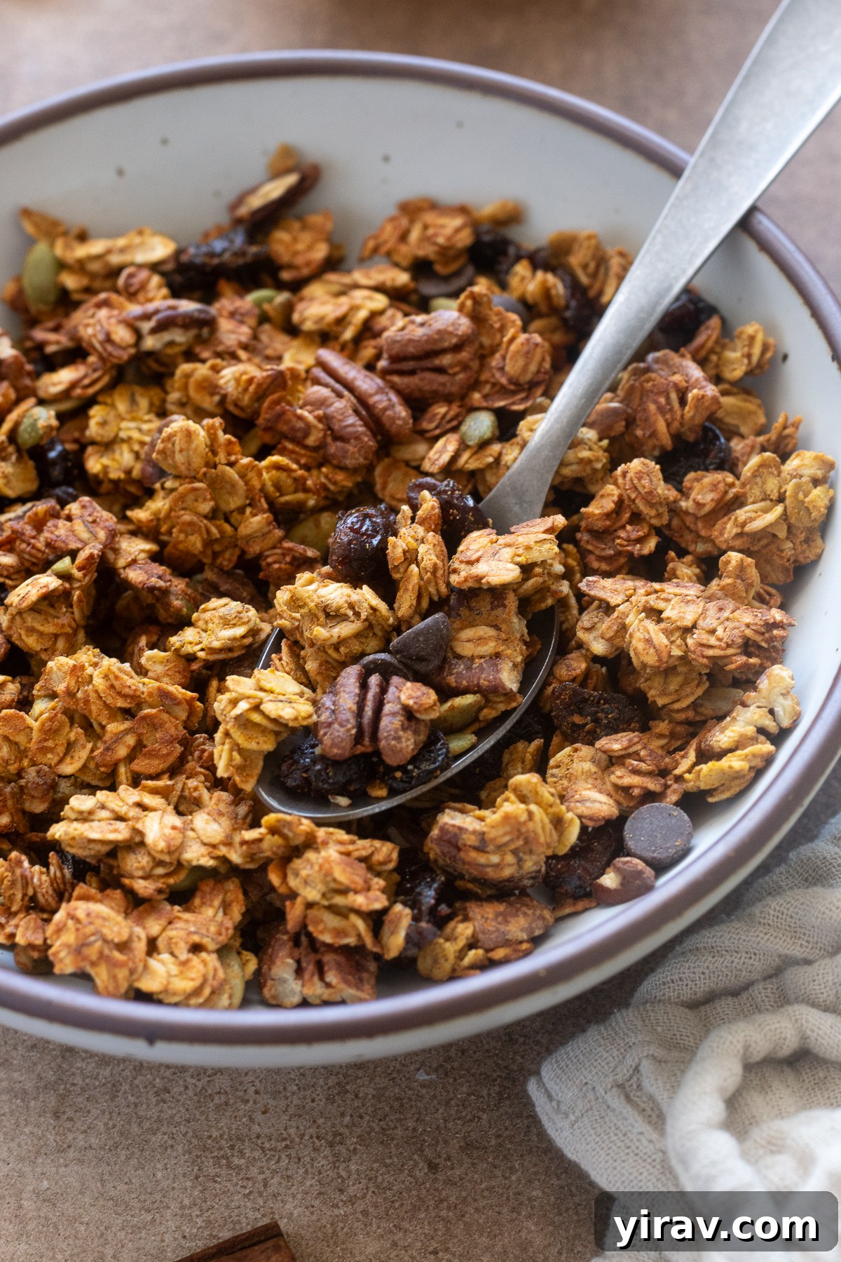 Spoonful of pumpkin spice protein granola in a bowl.
