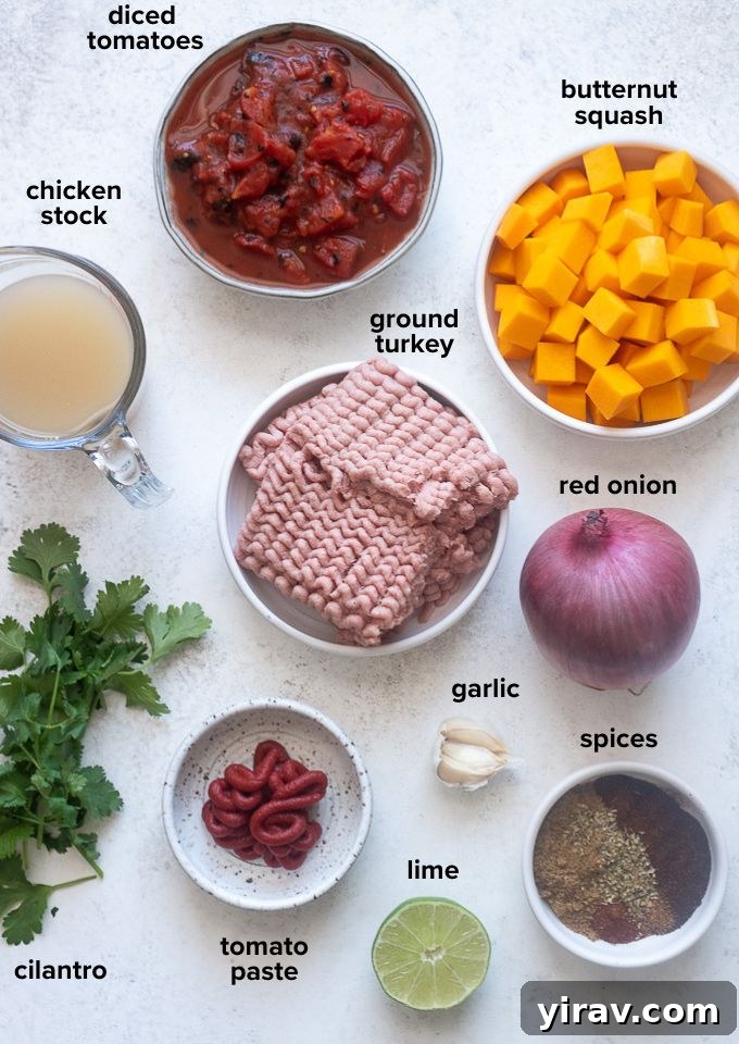 Hearty Butternut Turkey Chili 4 A selection of fresh ingredients laid out on a countertop, including ground turkey, butternut squash, onions, garlic, and various spices, ready for making chili.