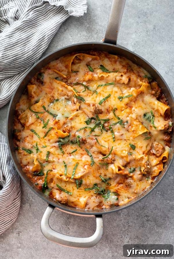 Overhead shot of skillet lasagna with chopped basil on top, highlighting its cheesy, comforting appeal for an easy, one-pot dinner