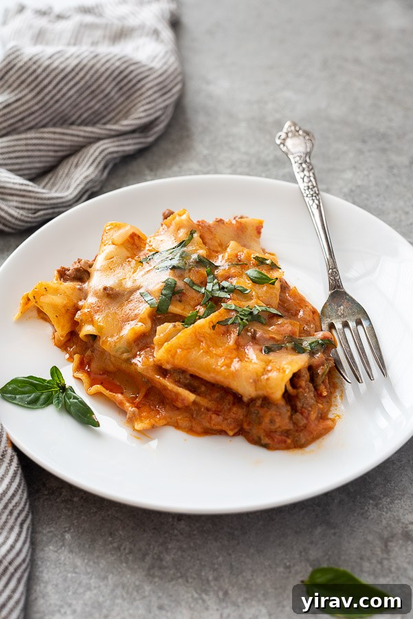 Close up of one pot lasagna on a plate with fork alongside, highlighting the texture and cheesiness