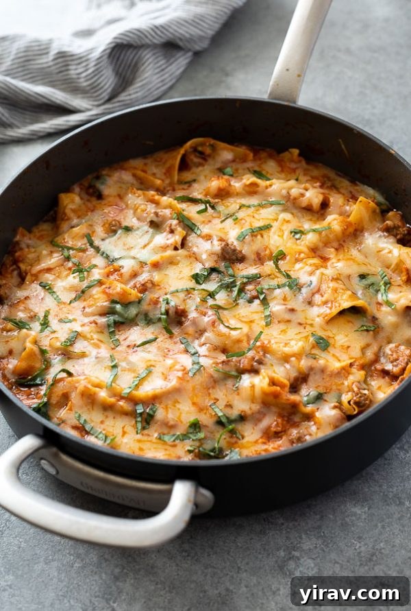 Front shot of skillet lasagna in a pan with basil on top, ready to be served as an easy and quick dinner