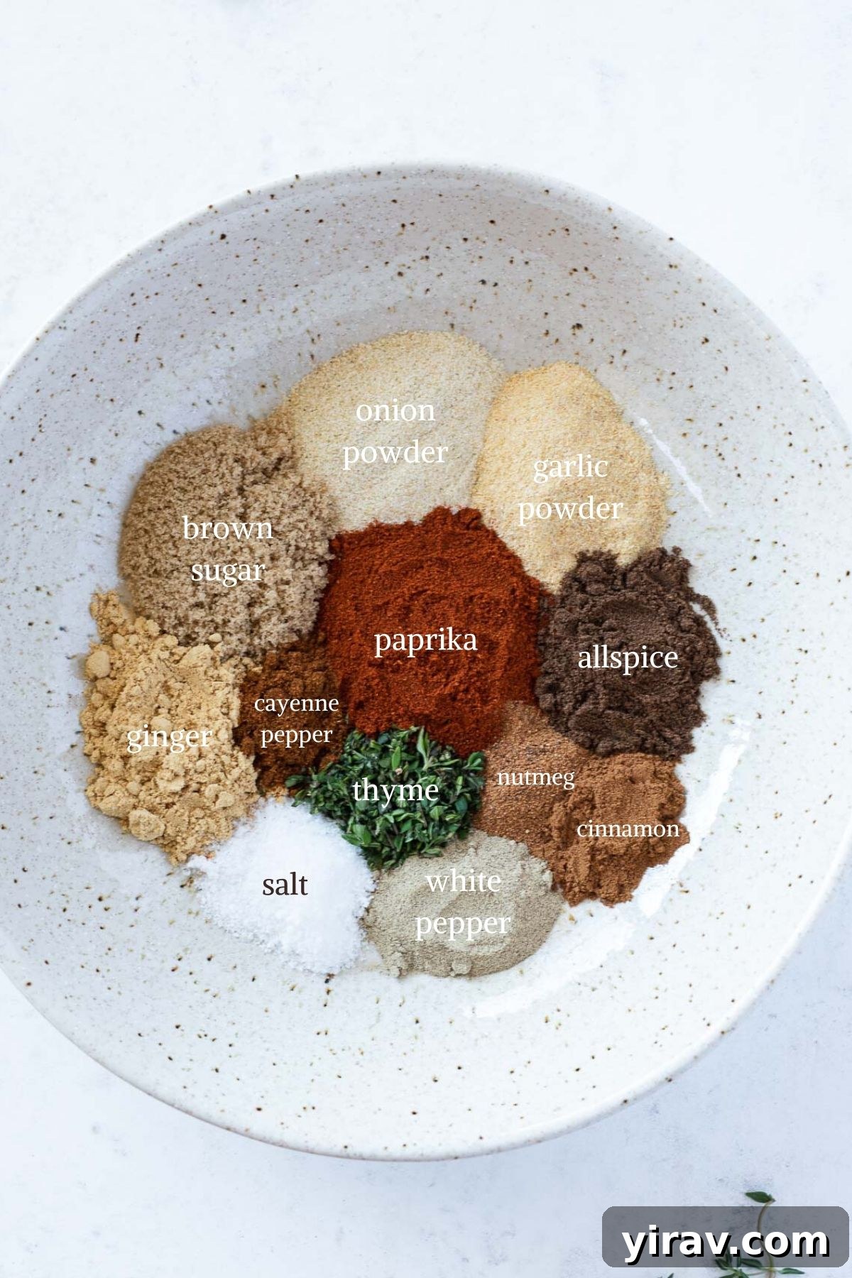 Individual ingredients for homemade jerk seasoning laid out in a white bowl
