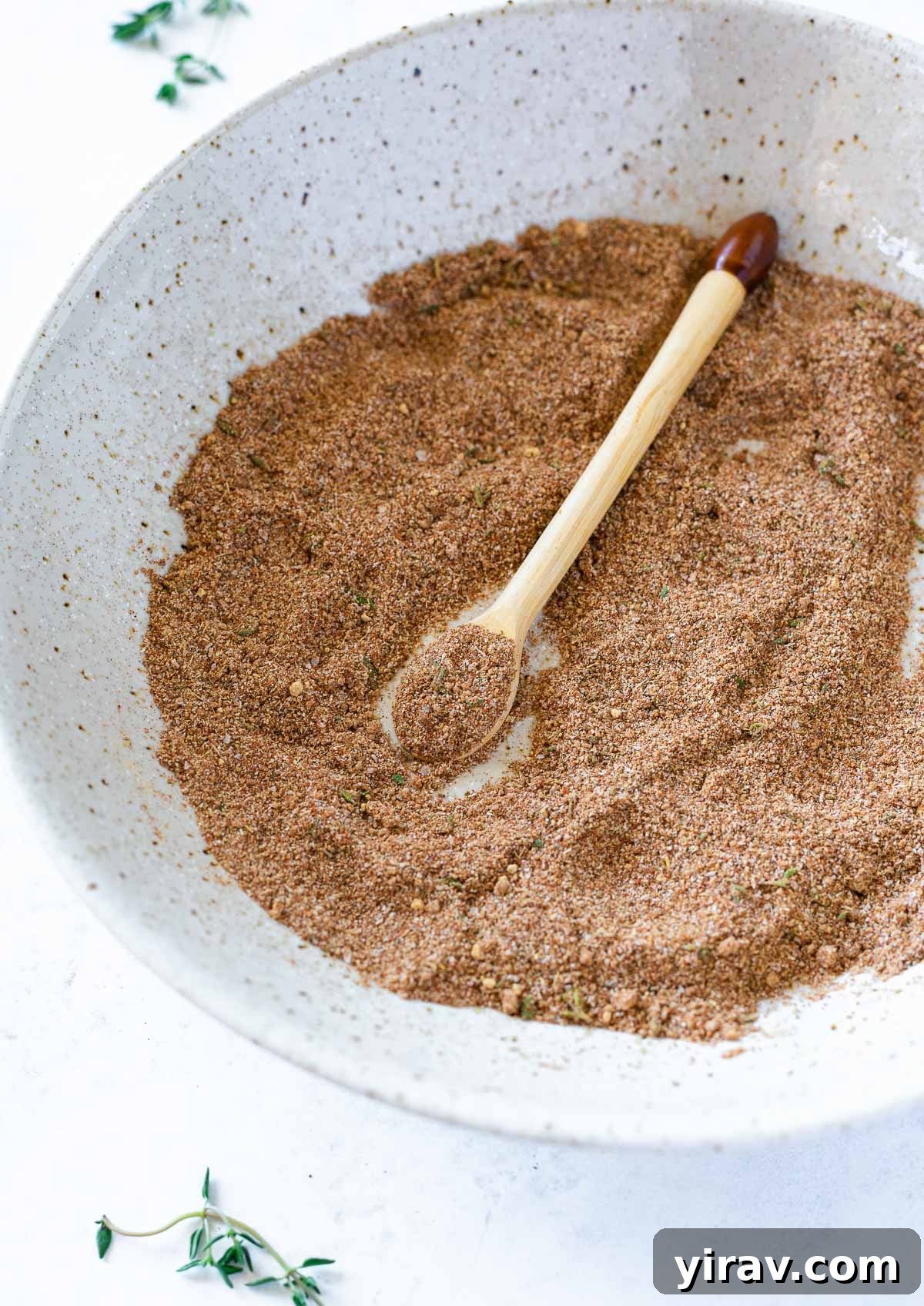 Blended homemade Jamaican Jerk Seasoning in a white bowl with a spoon