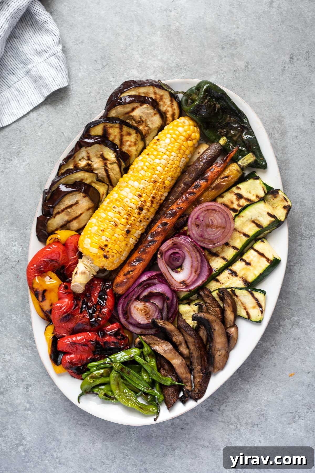 Grilled vegetables arranged on a white serving platter
