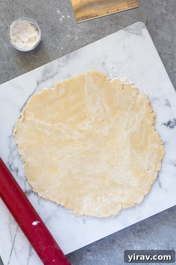 Galette dough rolled out onto marble board.