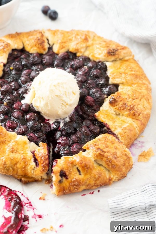 Blueberry galette with slice cut and ice cream in center