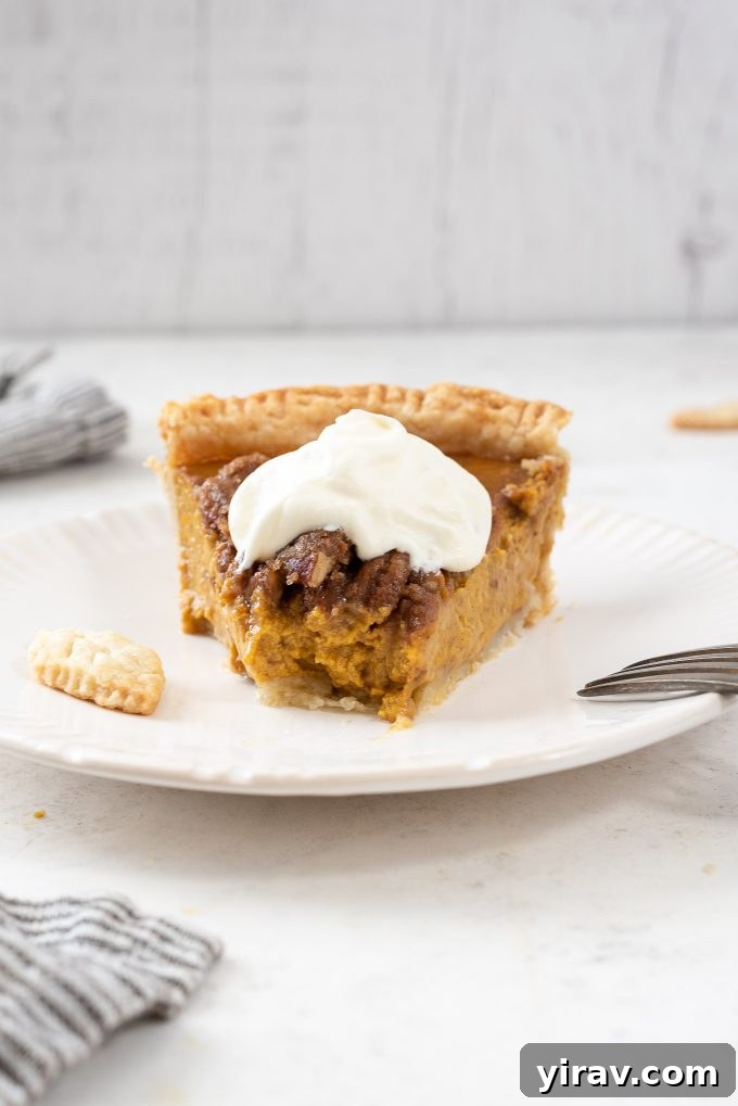 Close-up of a slice of Pumpkin Pecan Pie with a bite taken out, showing the texture of the filling and streusel.