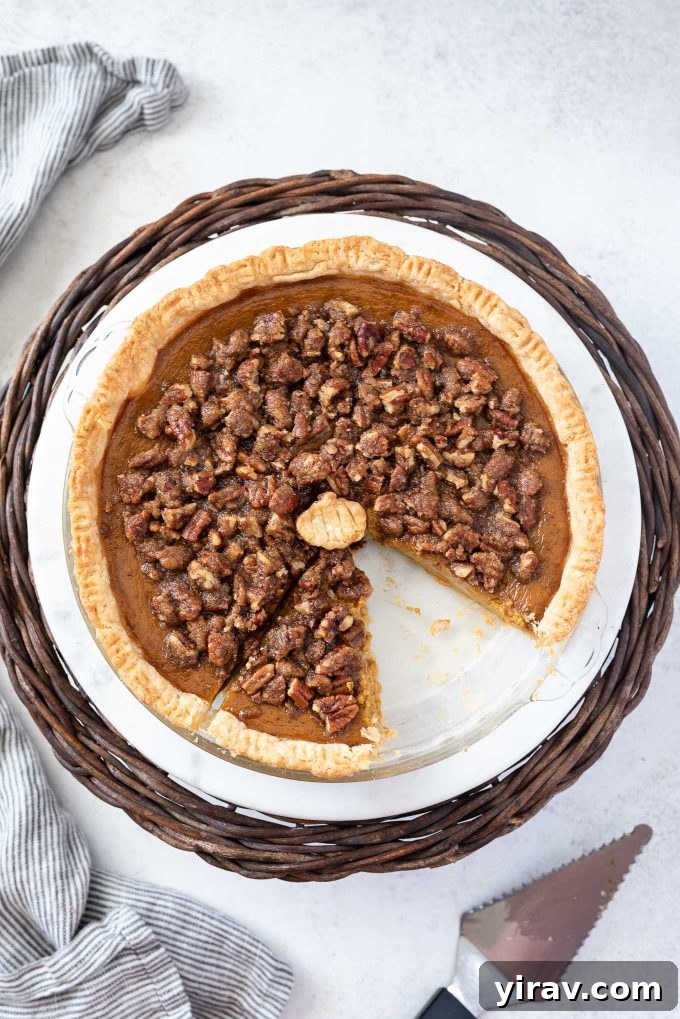 A perfectly baked Pumpkin Pecan Pie with a slice removed, showcasing its creamy pumpkin filling and generous pecan streusel.