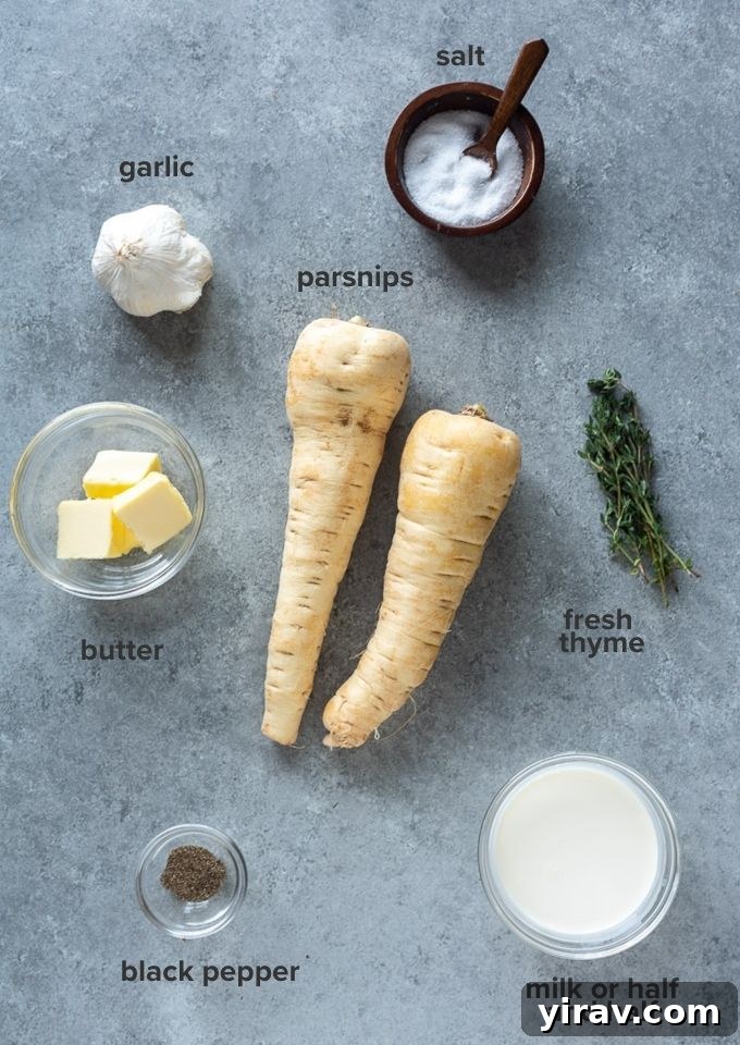 A flat lay shot of the ingredients for parsnip puree, including peeled and chopped parsnips, garlic cloves, butter, half and half, and fresh thyme sprigs.