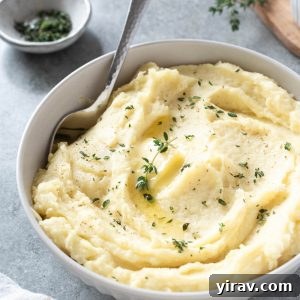 Parsnip puree in a white bowl with serving spoon digging in