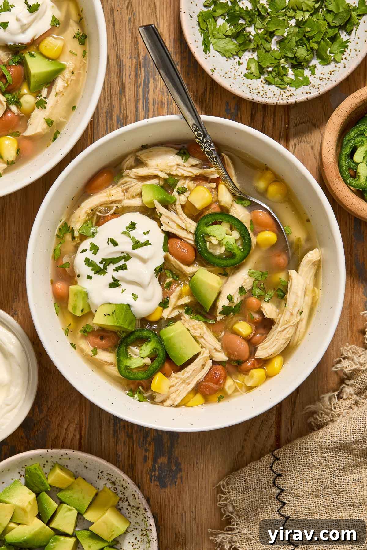 Crock Pot Green Enchilada Chicken Soup in a bowl with toppings.