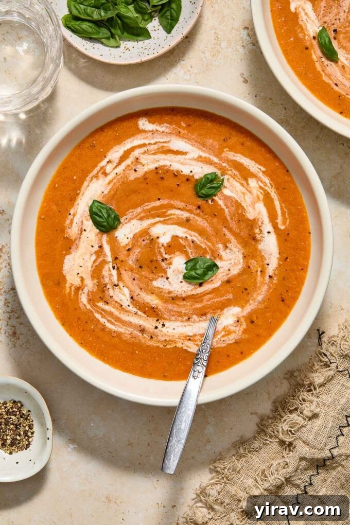 Creamy roasted tomato soup in a bowl with spoon.