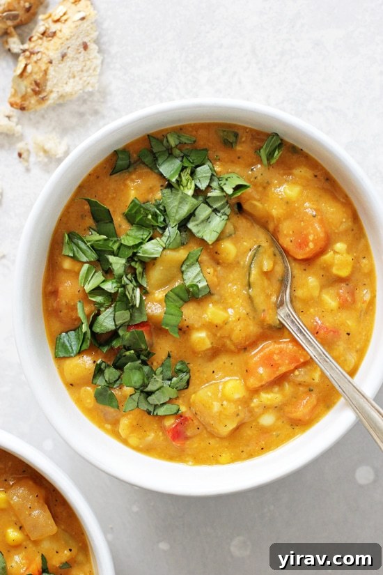 Dairy free corn chowder in a bowl with basil