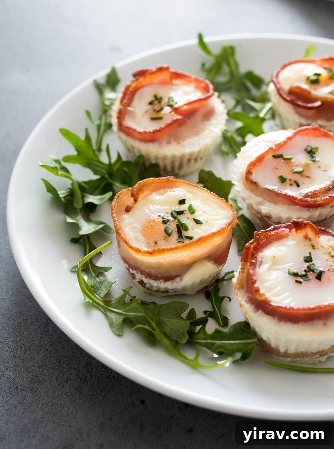 Crispy bacon and egg muffins on a white plate with fresh arugula garnish, perfect for a healthy breakfast or brunch.