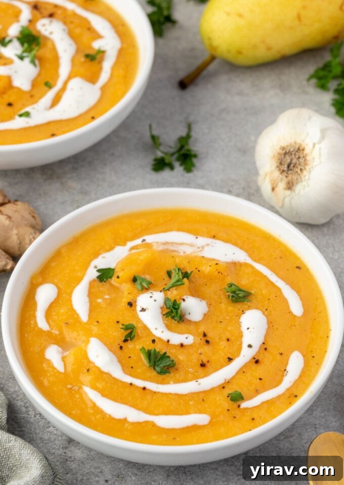 Close-up of roasted butternut squash and pear soup in a rustic bowl, garnished with coconut milk swirl and fresh parsley