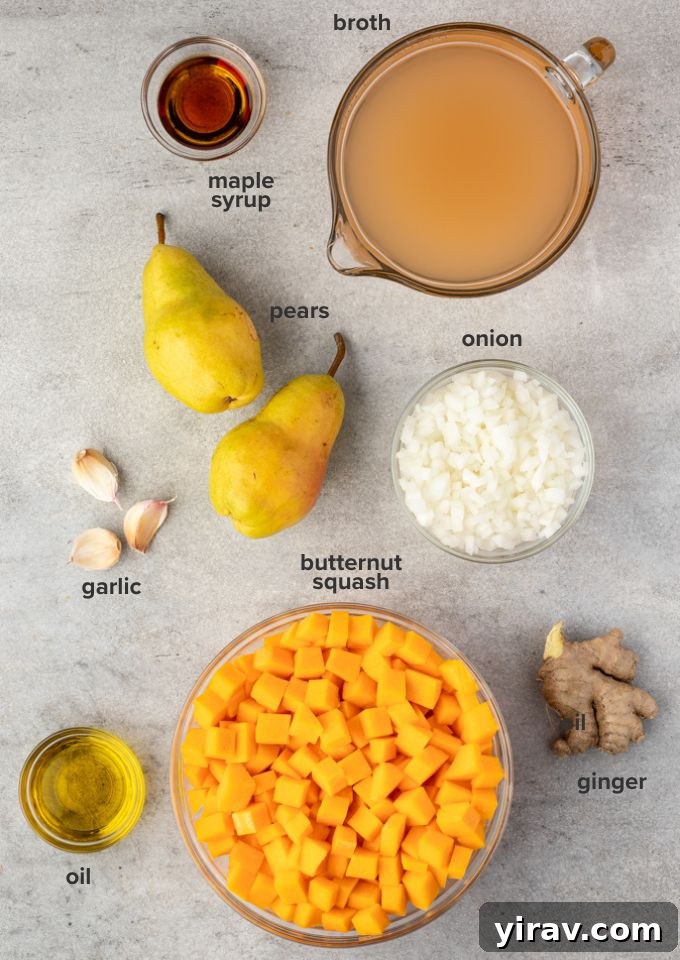Selection of fresh ingredients for butternut squash soup: whole butternut squash, pears, onion, garlic, ginger, vegetable broth, olive oil, and maple syrup