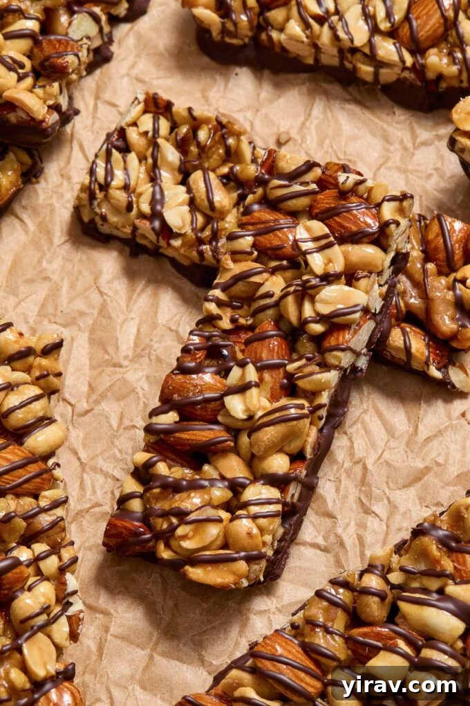 Homemade Kind nut bars cooling on parchment paper after being dipped in chocolate.
