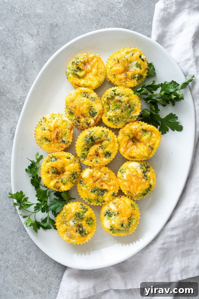 A beautiful arrangement of Mini Crustless Broccoli Quiche on a white platter, garnished with fresh parsley and a linen napkin for an elegant brunch setting.