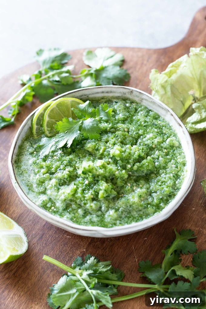 Fresh Tomatillo Salsa in a white bowl, garnished with lime and cilantro