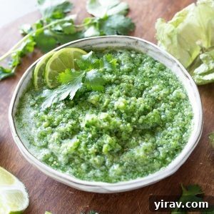 Tomatillo salsa recipe in a white bowl with lime and cilantro