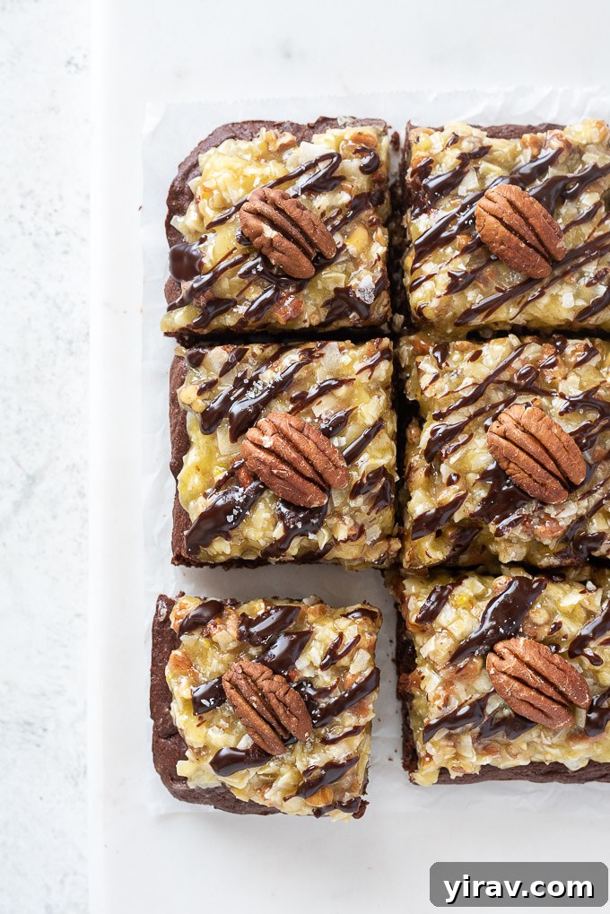 German Chocolate Cake Brownies 3 Perfectly cut squares of German Chocolate Brownies displaying the fudgy texture, coconut pecan frosting, and ganache drizzle.