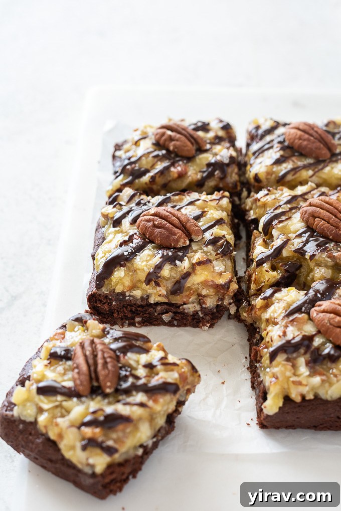 German Chocolate Cake Brownies 5 Close-up of freshly baked German chocolate brownies, sliced into squares, with toasted pecan halves on top of the coconut pecan frosting and ganache drizzle.