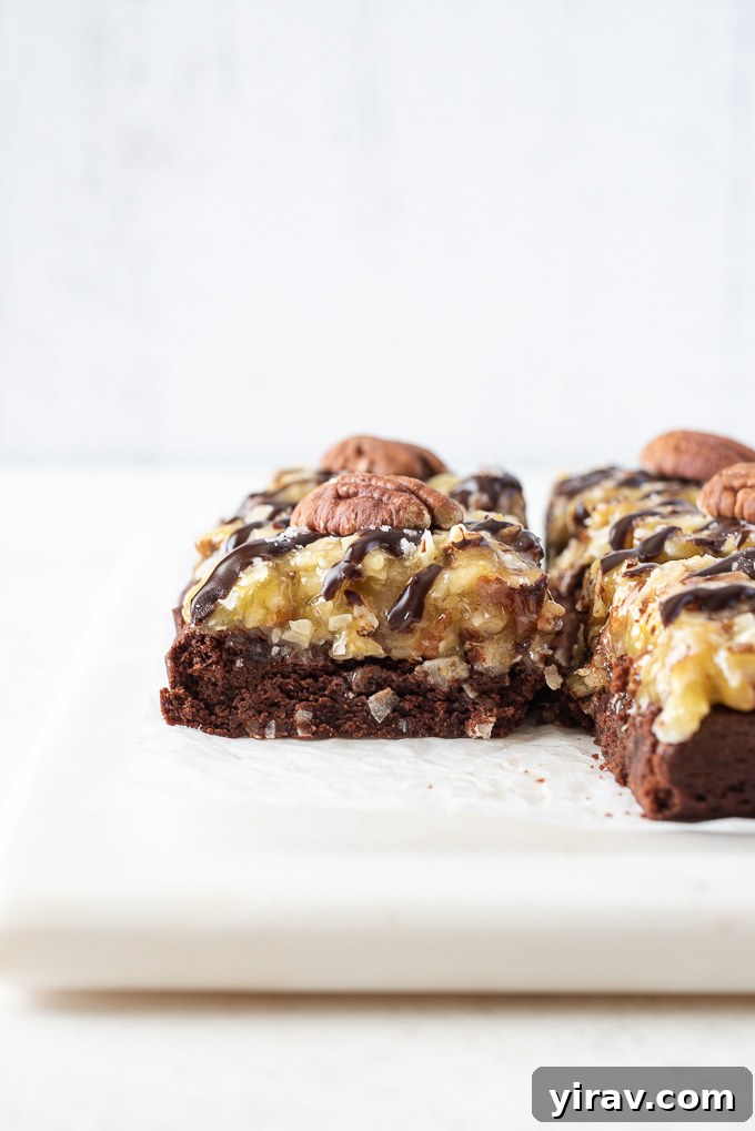 German Chocolate Cake Brownies 9 Close-up of a single German chocolate brownie, showing the fudgy brownie, coconut pecan frosting, and a whole pecan on top.
