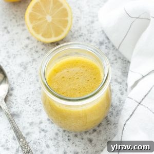 Lemon vinaigrette in a jar with a spoon nearby