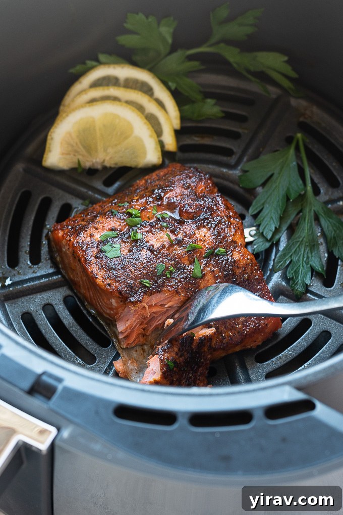 Effortless Air-Fried Salmon 6 Perfectly cooked salmon in the air fryer, being flaked with a fork
