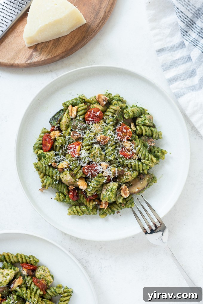 One pot chicken pesto pasta served on a white plate, ready to be enjoyed.