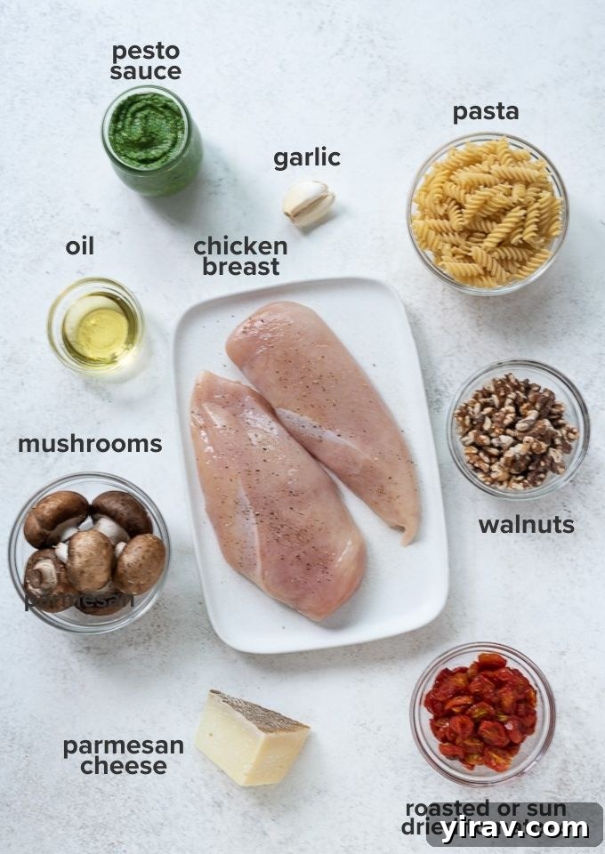 Various ingredients for chicken pesto pasta recipe laid out on a table.