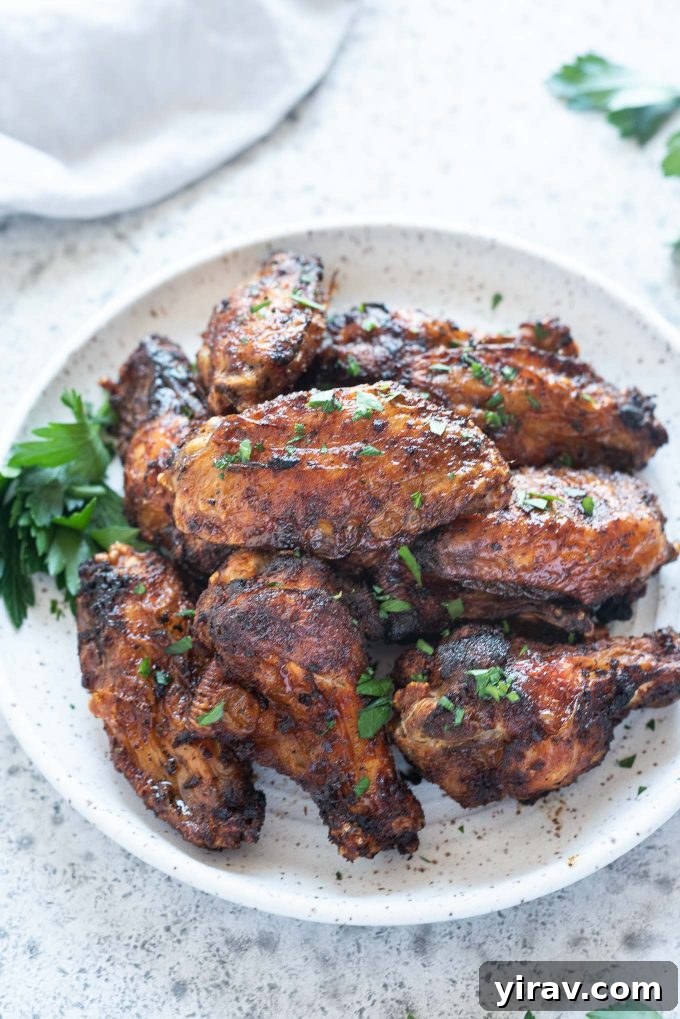 Air Fryer Wings: Crispy Perfection 2 Air fryer chicken wings piled high on a plate, garnished with fresh parsley