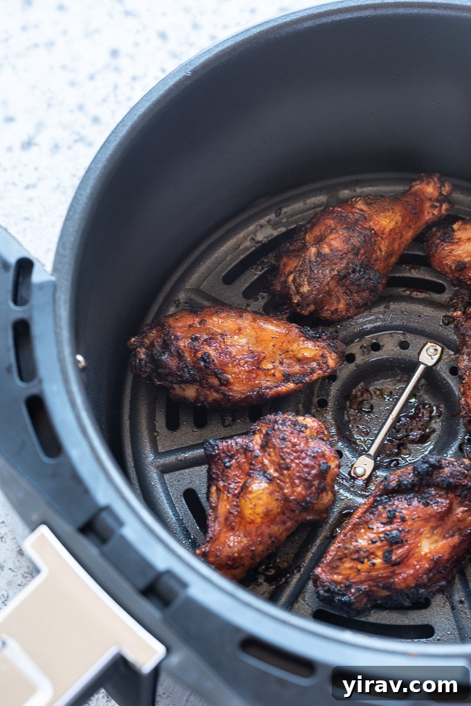 Air Fryer Wings: Crispy Perfection 7 Air fryer chicken wings cooking in the air fryer basket, perfectly golden and crispy