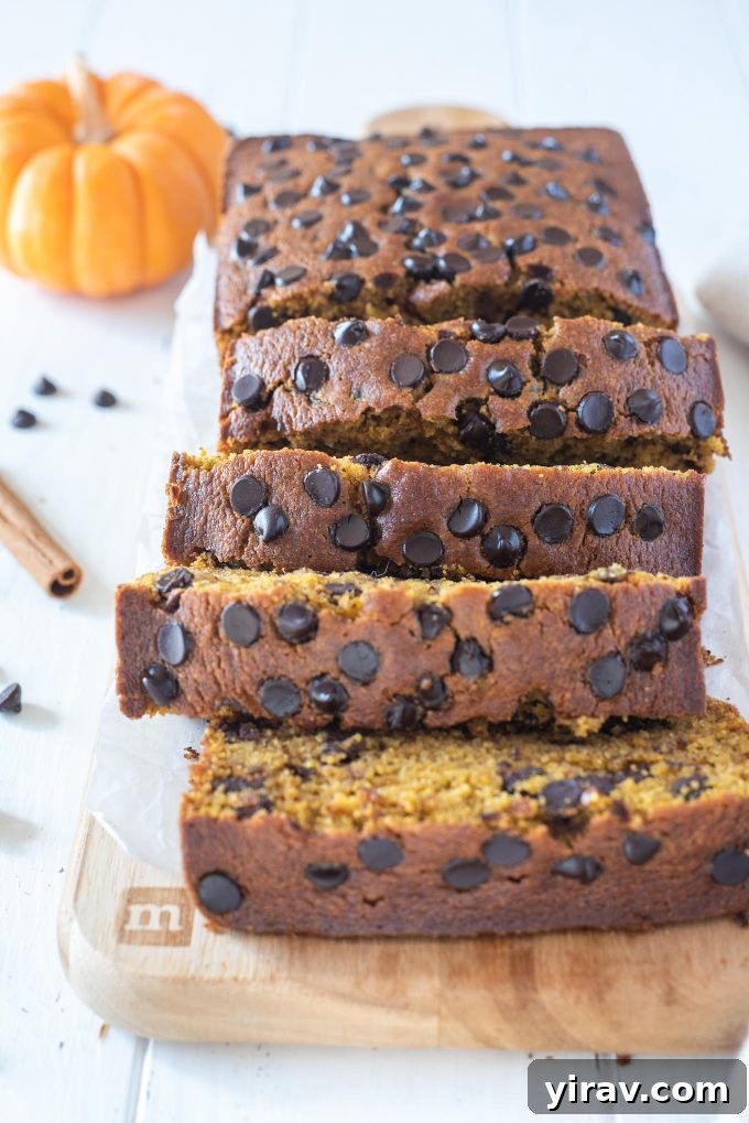 Slices of incredibly moist and hearty gluten-free pumpkin bread on a rustic cutting board, perfectly capturing the essence of fall baking.