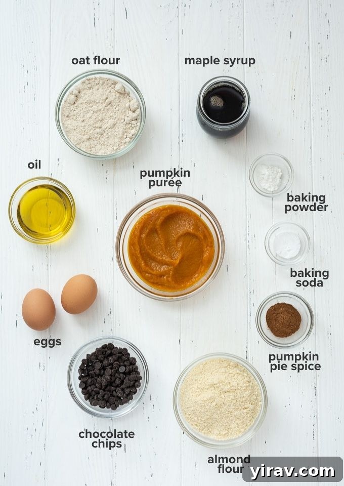 A vibrant flat lay showcasing all the fresh, wholesome ingredients needed to make this gluten-free pumpkin bread recipe, including pumpkin puree, flours, spices, and chocolate chips.