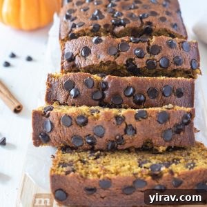 Slices of gluten-free pumpkin bread on a cutting board, garnished with a sprinkle of powdered sugar.