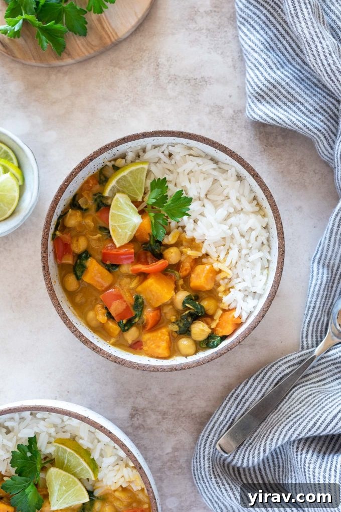 A vibrant bowl of Instant Pot Sweet Potato Chickpea Curry, garnished with fresh lime wedges and cilantro. The curry features tender sweet potatoes and chickpeas in a creamy, flavorful coconut sauce.