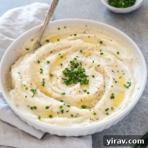 Creamy Garlic Mashed Cauliflower 9 Bowl of garlic mashed cauliflower with spoon digging in