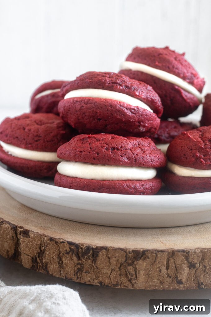 Red velvet whoopie pies piled on a plate.