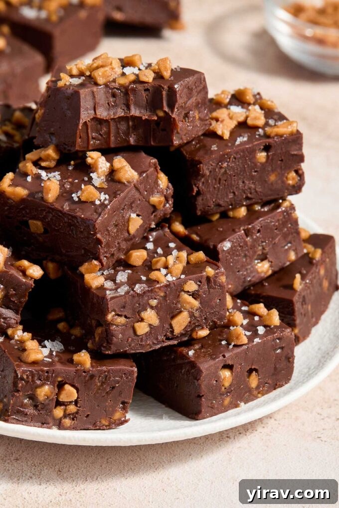 Squares of dark chocolate fudge piled on a plate.