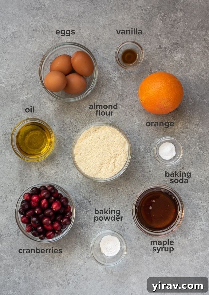 Zesty Cranberry Orange Muffins 4 A curated collection of fresh ingredients for healthy cranberry orange muffins, including vibrant cranberries, oranges, and a bowl of almond flour.