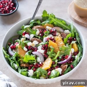 Arugula Citrus Jewel Salad 9 Arugula orange pomegranate salad in a white bowl with fork digging in