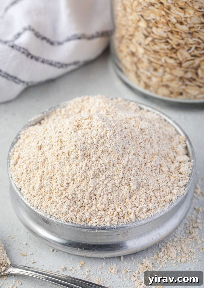 Homemade Oat Flour: Simple & Quick 2 Freshly ground oat flour in a bowl with a jar of whole rolled oats in the background, ready for baking.