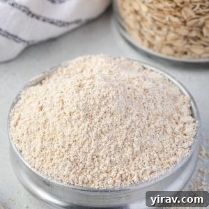 Homemade Oat Flour: Simple & Quick 9 Oat flour in a bowl with jar of oats behind